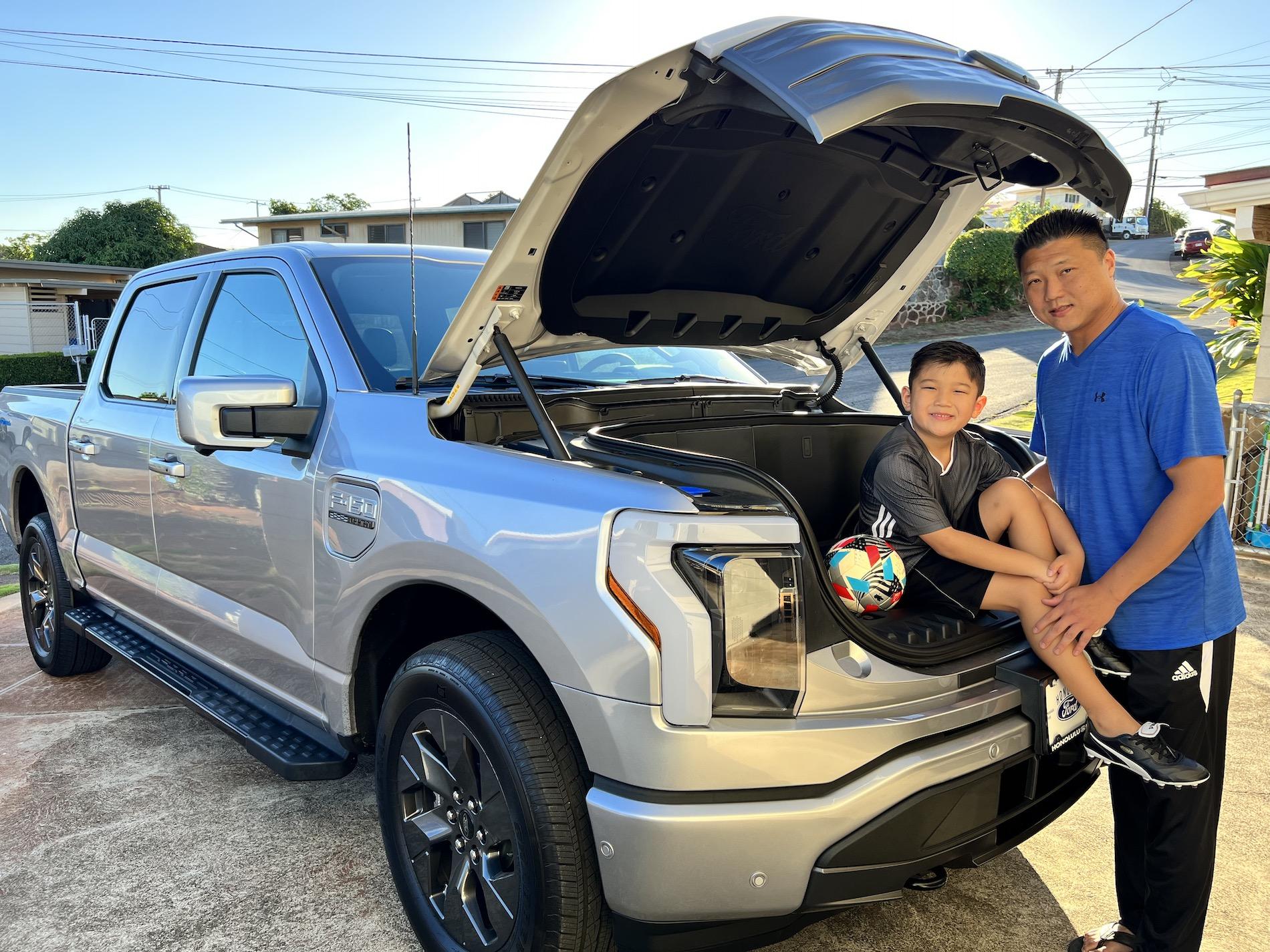 Ford F-150 Lightning Lightning Strikes Across America: Customer Deliveries Now Stretch Across All 50 States Aaron and son posing in front of Lightnin