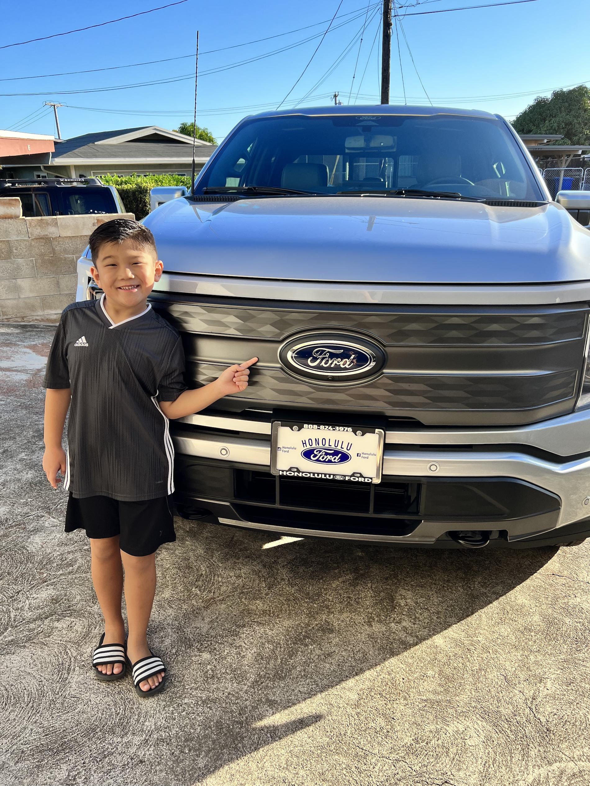 Ford F-150 Lightning Lightning Strikes Across America: Customer Deliveries Now Stretch Across All 50 States Aarons son posing in front of Lightnin