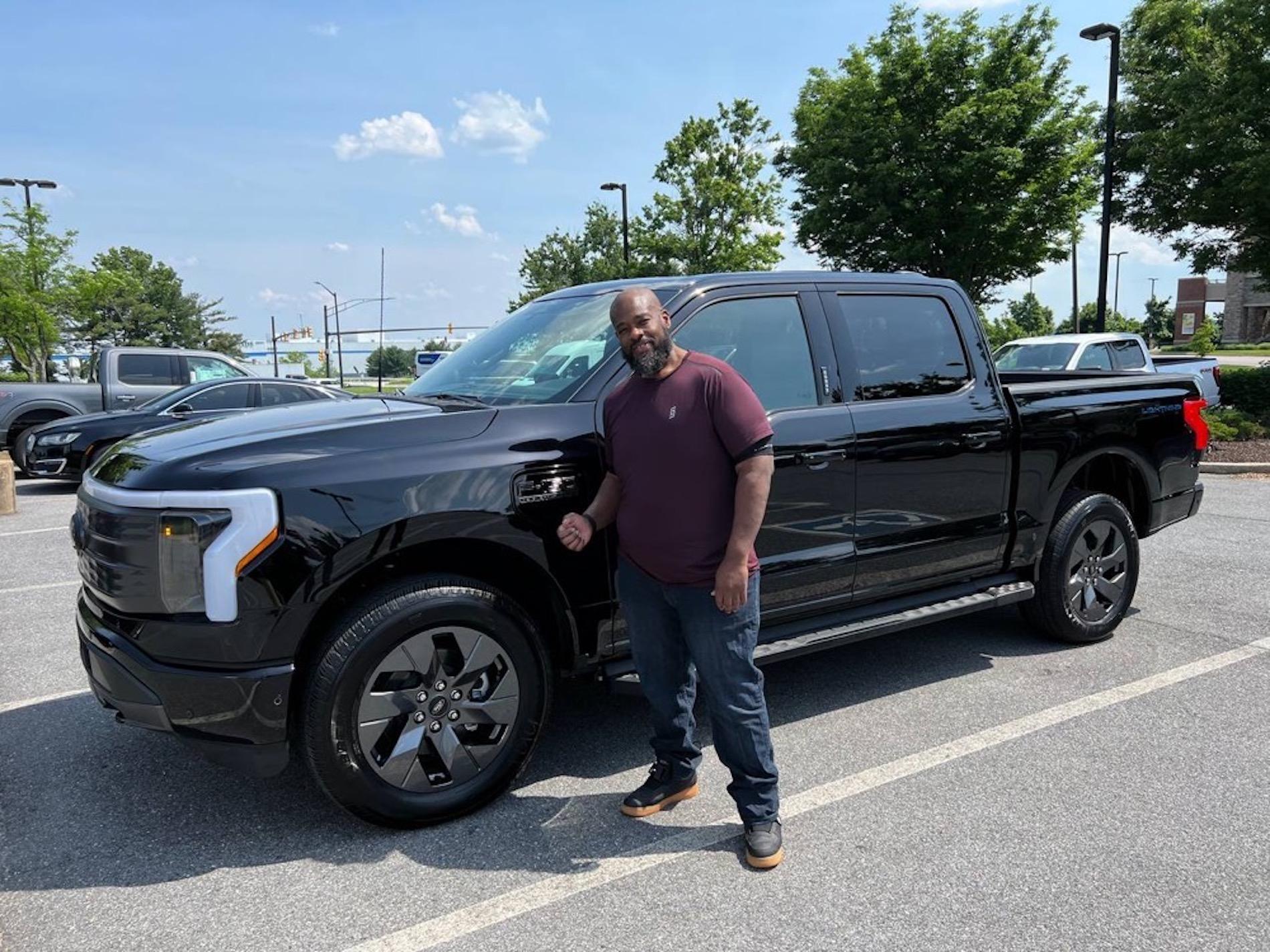 Ford F-150 Lightning Lightning Strikes Across America: Customer Deliveries Now Stretch Across All 50 States Chris posing in front of car